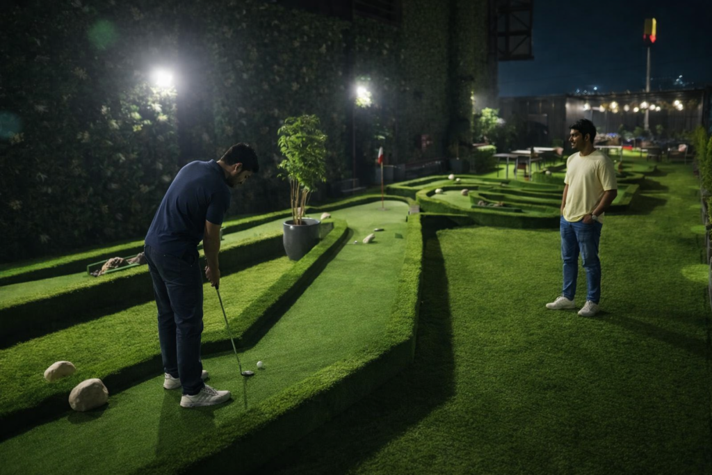 Mini golf in Gurgaon at Rumble Zone with two young adults playing on a modern green turf course at night