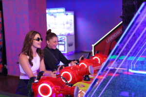 friends playing arcade game at Rumble Zone in The Vensej Mall gaming zone in gurgaon with neon lights
