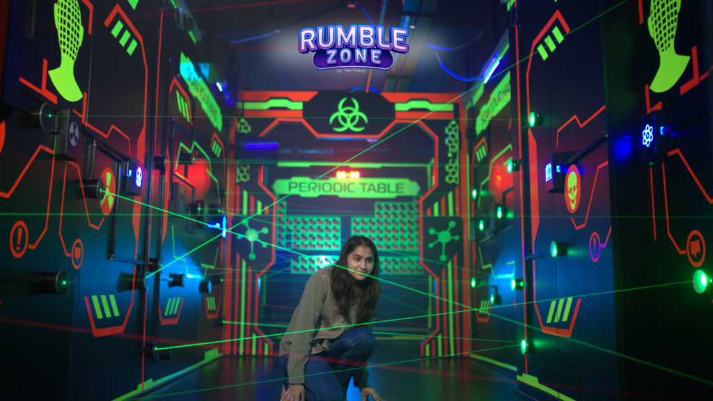 Woman navigating green laser beams during a laser war in Gurugram at Rumble Zone.